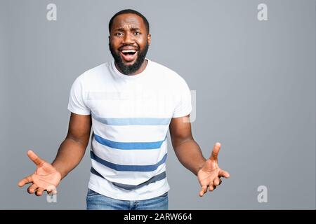 Schockierter afroamerikanischer Mann auf grauem Hintergrund Stockfoto