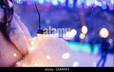 Mädchen hält Pappglas mit Kaffee oder heißem Tee im Winter in warmen Fäusten Stockfoto