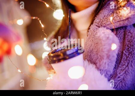 Mädchen hält Pappglas mit Kaffee oder heißem Tee im Winter in warmen Fäusten Stockfoto