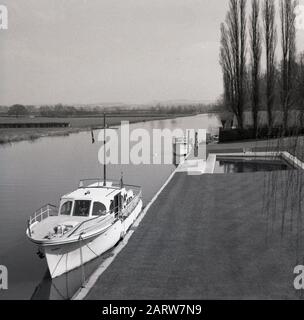 1960er Jahre, historisch, ein Motorkreuzer, der neben einem Grasverschnitt auf der Themse in der Nähe von Oxford, England, Großbritannien, vergraben wurde. Stockfoto