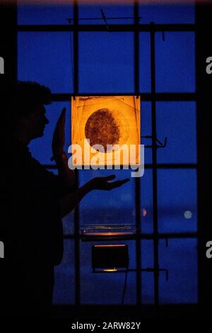 Der Künstler James Russell von JAMESPLUMB steht neben einem optischen Instrument mit einer Lichtprojektion durch Glas, die Silhouetten erzeugt, die die Mondoberfläche hervorrufen, im Mussenden Temple bei Castlerock im County Londonderry, wo er und Hannah Plumb Silent Light präsentieren werden, Die erste Installation mit Licht und dunklem Himmel, vom 9. Bis 23. Februar 2020, in Verbindung mit dem National Trust. Stockfoto