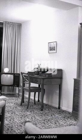 1970er Jahre, historische Innenansicht eines Loungebereichs eines Hauses mit einem antiken Schreibtisch und Fernseher der Epoche, England, Großbritannien. Stockfoto