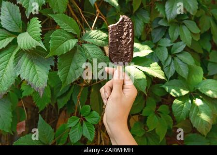 Weibliche Hand mit leckerer Eiscreme im Freien Stockfoto