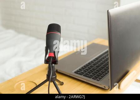Mikrofon und Laptop auf dem Tisch für die Aufnahme von Podcasts zu Hause. Technologie für das Blogging. Stockfoto