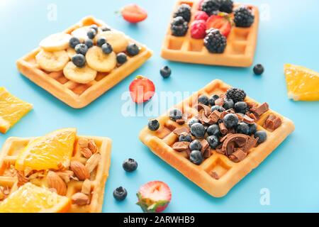 Leckere Waffeln mit Obst und Beeren auf Farbhintergrund Stockfoto