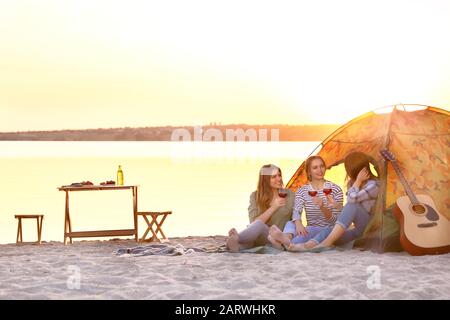 Junge Frauen, die ein Picknick in der Nähe des Flusses machen Stockfoto