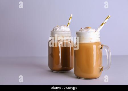 Mason Gläser leckeren Frappe-Kaffee auf grauem Hintergrund Stockfoto