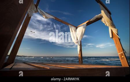 Low-Winkel-Aufnahme eines leeren hölzernen Pavillon in der Nähe der Meer unter blauem Himmel Stockfoto