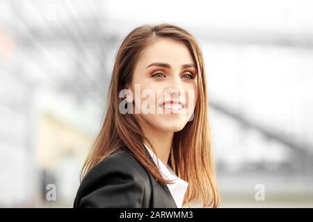 Wunderschönes Make-up. Schöne Frau, die sich in einem Geschäftsstil kleidet. Sie lächelt glücklich. Konzept für Lifestyle, Business, Bewegung, Motivation. Stockfoto