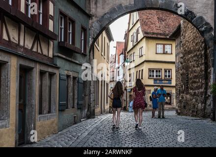 Rothenburg ob der Tauber, Bayern / Deutschland - 08 08 08 2018: Junge schöne Frau in Sommerkleidern in den Sreets der Altstadt spazieren Stockfoto