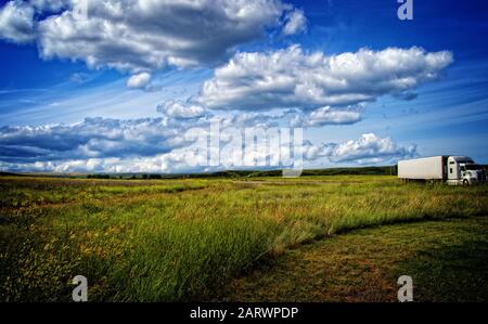 18 Wheeler Fahrt durch schöne Landschaft mit schönen Wolken, Stockfoto