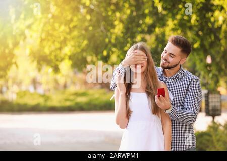 Junger Mann, der seiner geliebten Natur vorschlägt Stockfoto