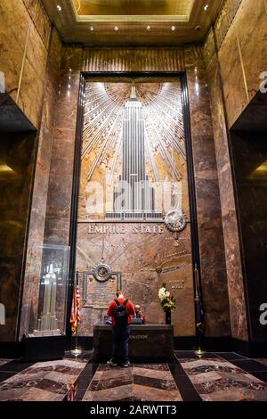 New YORK CITY (MANHATTAN), NY/USA - 21. JANUAR 2018: Touristen bitten um Informationen an der Haupteingangsstelle des Empire State Building. Stockfoto