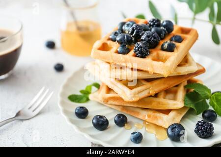 Teller mit süßen leckeren Waffeln auf weißem Tisch Stockfoto