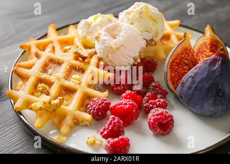 Teller mit leckeren Waffeln, Beeren und Feigen auf dem Tisch, Nahaufnahme Stockfoto