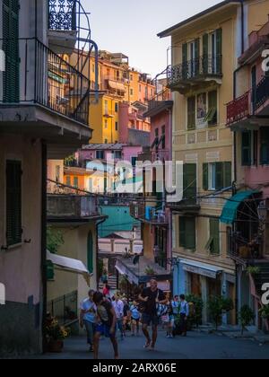 Manarola, ITALIEN - Juli 07, 2019: Touristen gehen die Hauptstraße vorbei an Cafés und Geschäften auf dem Weg zum Meer im Cinque Terre Dorf Manarola, It Stockfoto