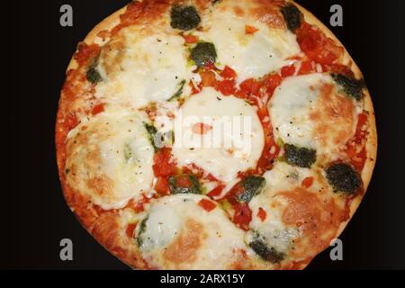 Hausgemachte vegetarische Pizza mit geschmolzenem Mozzarella-Käse, Tomaten und Gewürzen Stockfoto