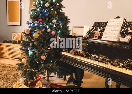 Grand Piano im Zimmer, das zu Weihnachten dekoriert ist Stockfoto