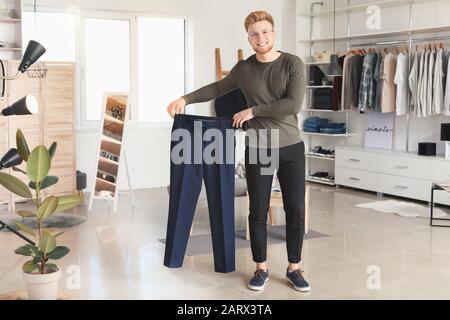 Schöner Mann mit stilvoller Kleidung in der Umkleidekabine Stockfoto