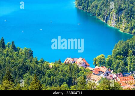 Landschaft der Alpenberge, Bayern, Deutschland. Landschaft mit blauem Wasser im Alpsee im Sommer. Schöne Landschaft mit Dorf Hohenschwangau im Grünen f Stockfoto
