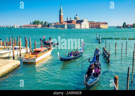 Venedig - 18. Mai 2017: Gondeln schwimmen in der Nähe des Markusplatzes in Venedig, Italien. Die Gondel ist der attraktivste Touristentransport Venedigs. Wunderschöner VI Stockfoto