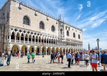 Venedig, Italien - 19. Mai 2017: Dogenpalast oder Palazzo Ducale an einem sonnigen Tag. Touristen gehen auf der Piazza San Marco. Dies ist die wichtigste touristische Destinatio Stockfoto