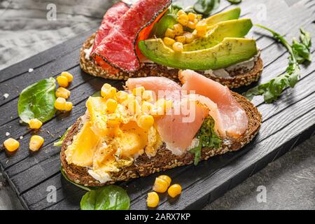 Leckere Sandwiches auf Holzbrett Stockfoto