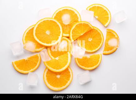 Frische orangefarbene Scheiben mit Eiswürfeln auf weißem Hintergrund Stockfoto