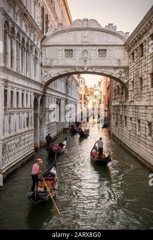 Venedig, Italien - 18. Mai 2017: Gondeln mit Touristen fahren entlang des schmalen Kanals unter der berühmten Seufzerbrücke im Dogenpalast. Die Gondel Stockfoto