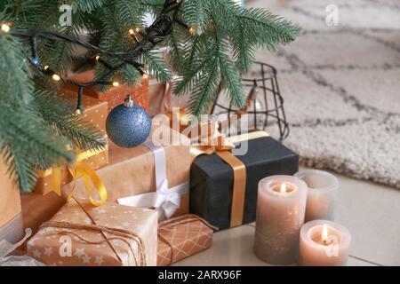 Kerzen und Geschenkschachteln unter dem Weihnachtsbaum Stockfoto