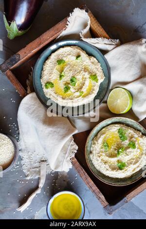 Köstliches Eggpflanzen-Bad Baba Ganoush mit Sesamsamen und Olivenöl, serviert mit Pita Brot auf rustikalem Hintergrund Stockfoto