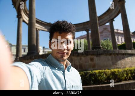 Junger Mann im zentralen Park von Quetzaltenango, der ein selfie nimmt Stockfoto