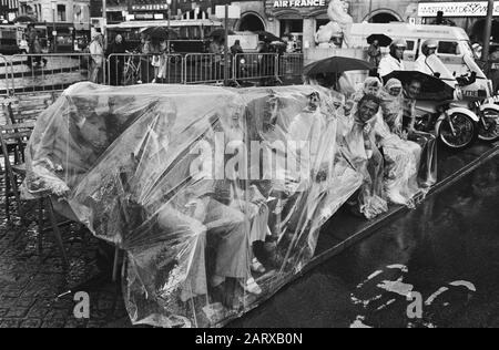 Zuschauer unter Plastikdatum: 3. September 1983 Ort: Amsterdam, Noord-Holland Schlagwörter: Blumenkorsos, öffentlich, Regen Stockfoto