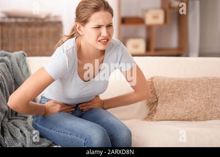 Junge Frau mit Bauchschmerzen zu Hause Stockfoto