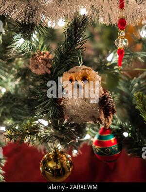 Nahaufnahme eines dekorierten künstlichen Weihnachtsbaums mit Eule- und Kugelornamenten. Stockfoto