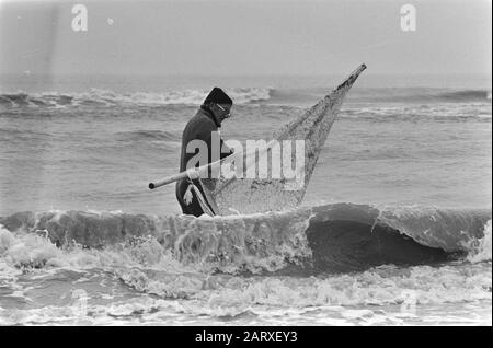 Traditionelles Neujahrstauchen im Meer in der Nähe von Zandvoort. Surfer in Zee in Zandvoort Datum: 1. Januar 1982 Ort: Noord-Holland, Zandvoort Schlüsselwörter: Surfer Stockfoto