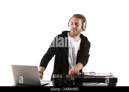 Männlicher dj, der Musik auf weißem Hintergrund spielt Stockfoto