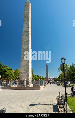 Istanbul - 26. MAI 2013: Touristen, die das alte Hippodrom am 26. Mai 2013 in Istanbul, Türkei besuchen. Der Ummauerte Obelisk (vorne) und der Obelisk von T Stockfoto