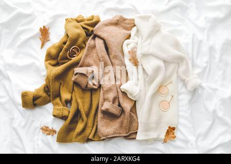 Komposition mit Kleidung für Herbstwetter auf weißem Stoff Stockfoto