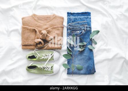 Komposition mit Kleidung für Herbstwetter auf weißem Stoff Stockfoto