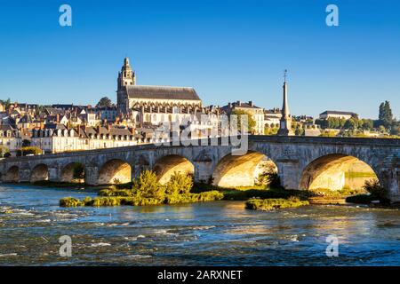 Alte Brücke über die Loire-Brücke bei Sonnenuntergang in Blois, Frankreich. Kathedrale von Blois im Hintergrund. Stockfoto