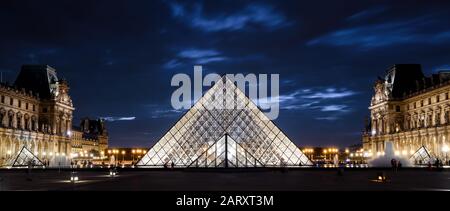 Paris - 25. September 2013: Louvre in der Nacht in Paris. Der berühmte Louvre ist eines der beliebtesten Reiseziele in Frankreich. Panoramablick auf den Louvre und das Glas Stockfoto