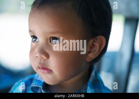 Ein etwa zwei Jahre alter kleiner Junge, der traurig, aufsehenvoll und nachdenklich aussieht; nach dem Weinen. Stockfoto