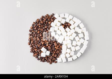 Yin-Yang-Symbol aus Kaffeebohnen und Zucker auf hellem Hintergrund Stockfoto