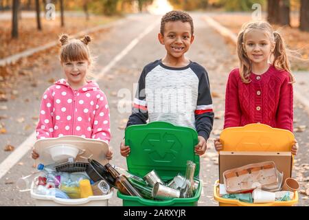 Kleine Kinder sammeln Müll im Freien. Recycling-Konzept Stockfoto