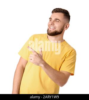 Gutaussehender junger Mann, der auf etwas auf weißem Hintergrund zeigt Stockfoto