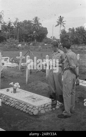 Dr. Mansuer in Medan (Wali Negara Sumatera Timoer); Weihnachtsfeier 3.4-i R.I. Canoe-Plateau; Militärkrankenhaus; Blumen-Tribut an Gräber Zwei Soldaten, die auf einem Friedhof in der Nähe des Grabes von H. Berkel aus der 9. afd stehen. Artillerie-Anmerkung: S 21 Jahr Geboren am 1. Mai 1926 in Den Haag Starb am 19. August 1947 in Sibolangit Datum: 25. Dezember 1947 Standort: Indonesien, Niederländische Ostindien Stockfoto