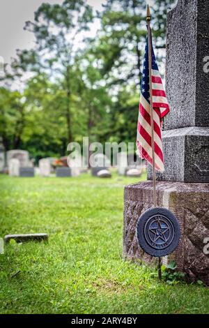 Eine amerikanische Flagge auf dem Grab eines amerikanischen Veteranen auf einem Friedhof in Wisconsin. Stockfoto