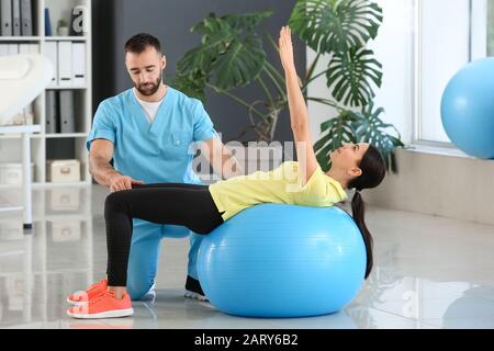 Physiotherapeutin arbeitet mit weiblicher Patientin im Rehabilitationszentrum Stockfoto