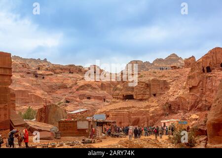Petra, Jordanien - 4. Januar 2020: Straße der Fassaden, ein Name der Reihe der monumentalen Nabatäischen Gräber, die in der südlichen Felswand eingemeißelt sind. Die Leute besuchen Petra Stockfoto
